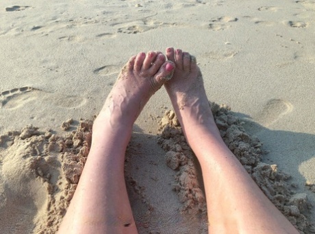 Kinky MILF with long legs Lara poses on the beach and teases with her feet