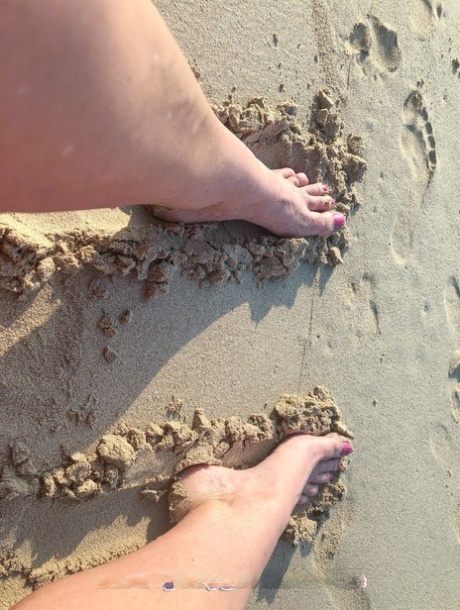 Kinky MILF with long legs Lara poses on the beach and teases with her feet